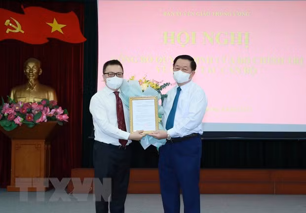 Bí thư Trung ương Đảng, Trưởng Ban Tuyên giáo Trung ương Nguyễn Trọng Nghĩa trao quyết định Phó Trưởng Ban Tuyên giáo Trung ương cho đồng chí Lê Quốc Minh. (Ảnh: Phương Hoa/TTXVN)