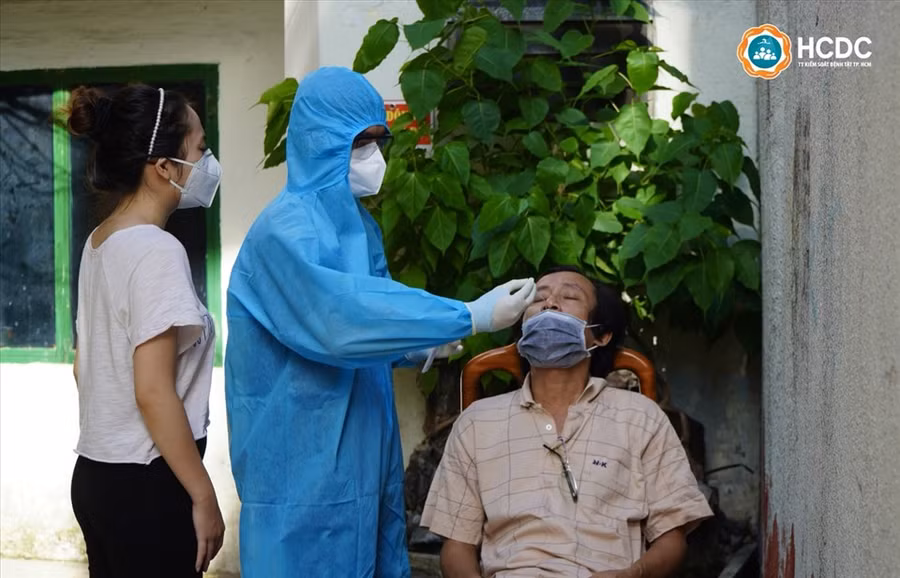 Nhân viên y tế hướng dẫn kỹ thuật lấy mẫu test nhanh cho người dân. Ảnh: HCDC