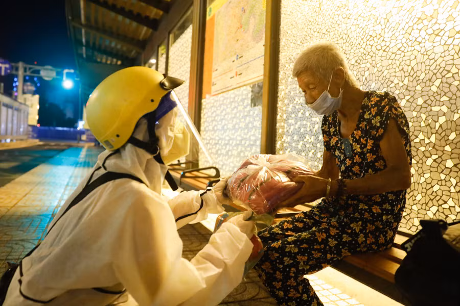 Dịu Hiền trao cho cụ Dung chiếc mền đắp cho đỡ lạnh trong đêm Sài Gòn bị ảnh hưởng giông bão. Ảnh: Lam Ngọc