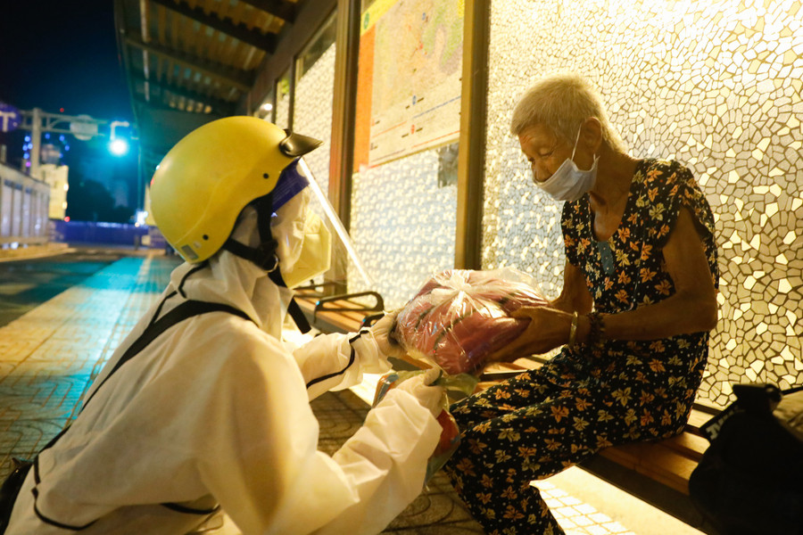 Dịu Hiền trao cho cụ Dung chiếc mền đắp cho đỡ lạnh trong đêm Sài Gòn bị ảnh hưởng giông bão. Ảnh: Lam Ngọc