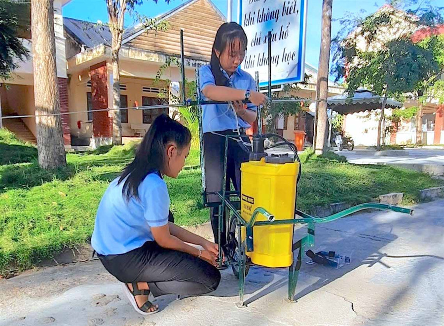 Nguyễn Dương Thu Uyên (đứng) và Huỳnh Trần Thùy Linh (học sinh Trường THPT Chu Văn An, huyện Krông Pa) đang chế tạo mô hình xe phun thuốc đa dụng. Ảnh: Mộc Trà