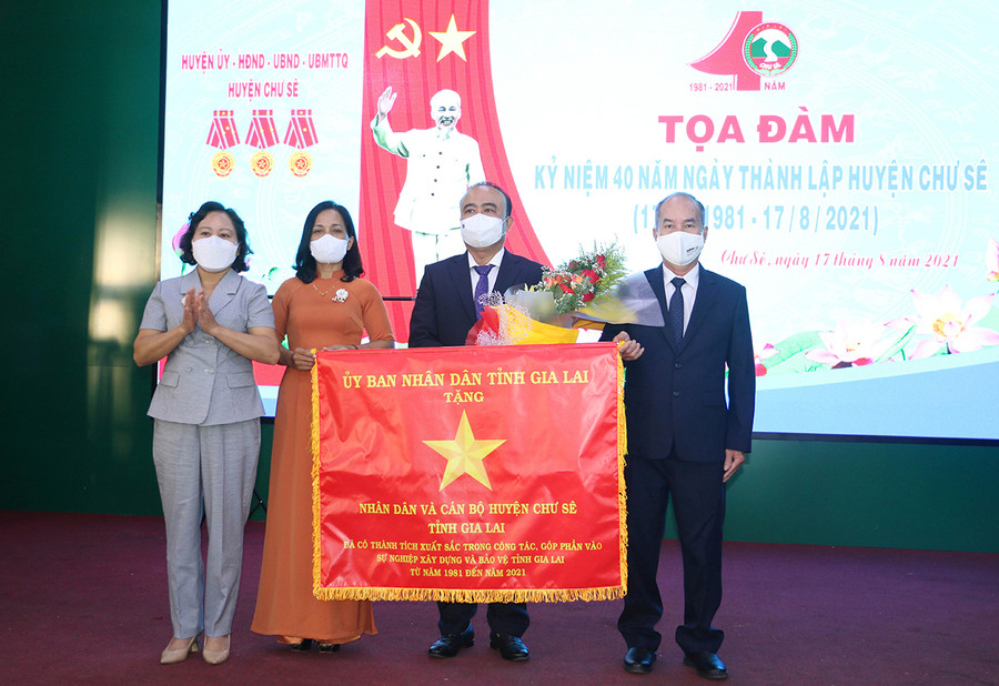 Thừa ủy nhiệm của Chủ tịch UBND tỉnh, Phó Chủ tịch HĐND tỉnh Ayun H'Bút đã tặng cờ Vì sự nghiệp xây dựng và bảo vệ tỉnh Gia Lai cho nhân dân và cán bộ huyện Chư Sê. Ảnh: Quang Tấn