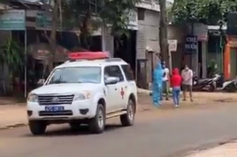 Cô gái là F1 (áo đỏ) được nhân viên y tế thuyết phục, đưa trở lại khu cách ly. Ảnh: Cắt từ clip