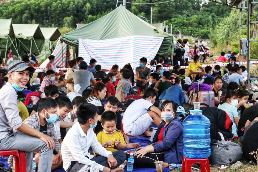 Chị Như, anh Nhận cùng hơn 30 người trú cùng xã Phong Chương, H.Phong Điền, tỉnh Thừa Thiên - Huế ngồi chờ được đưa đi cách ly tập trung. Ảnh: D.B