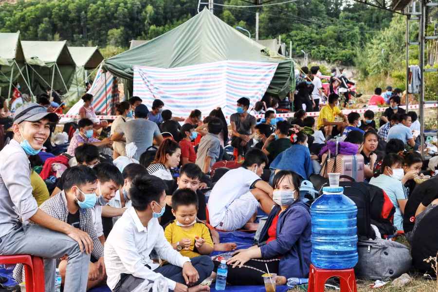 Chị Như, anh Nhận cùng hơn 30 người trú cùng xã Phong Chương, H.Phong Điền, tỉnh Thừa Thiên - Huế ngồi chờ được đưa đi cách ly tập trung. Ảnh: D.B