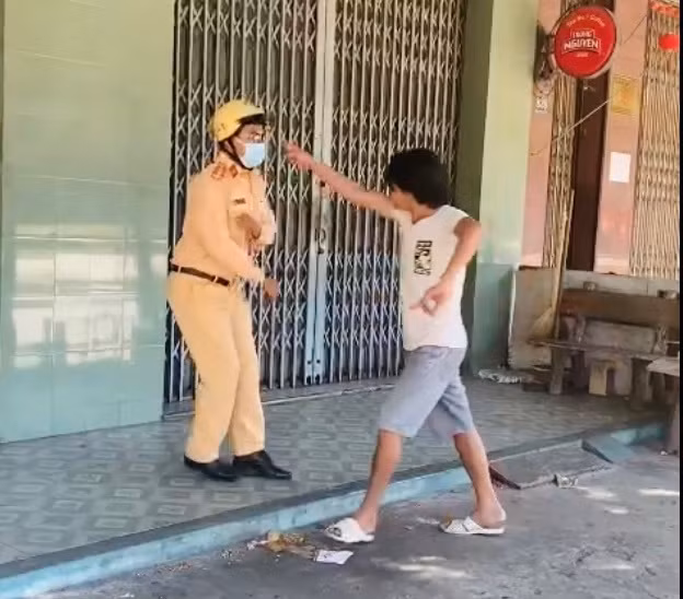 Không đeo khẩu trang, ngồi ở vỉa hè khi bị nhắc nhở, người đàn ông dùng ghế tấn công lực lượng công an - Ảnh chụp lại màn hình Không đeo khẩu trang, ngồi ở vỉa hè khi bị nhắc nhở, người đàn ông dùng ghế tấn công lưc lượng công an - Ảnh chụp lại màn hình