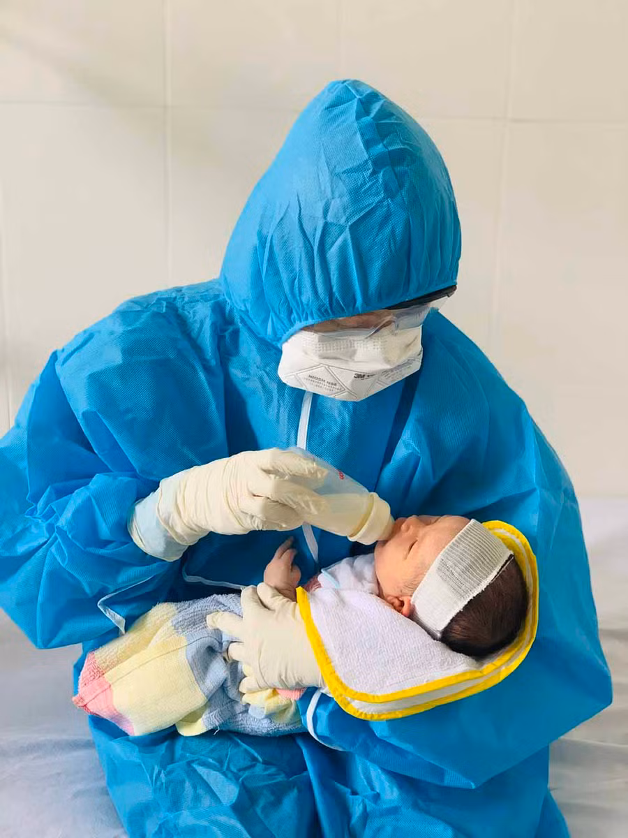 10-8-2021Nhân viên y tế Bệnh viện Nhi Gia Lai thay phiên chăm sóc cho bé trai con sản phụ F0. Ảnh Như Nguyện