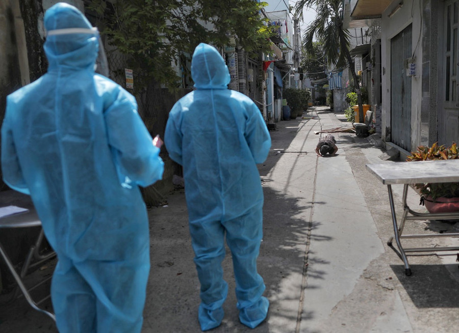 Con gái bà T.T.L (P.Bình Hưng Hòa A, Q.Bình Tân) chắp tay vái lạy đón tro cốt mẹ từ xa khi các cán bộ phường đưa di cốt bà L. về nhà