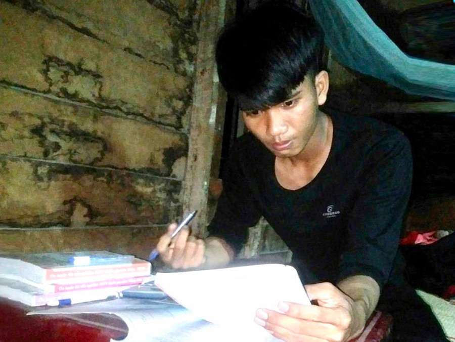 Vì phải phụ giúp cha mẹ công việc ban ngày nên em Ksor Vit chỉ học bài vào buổi tối (ảnh nhân vật cung cấp).