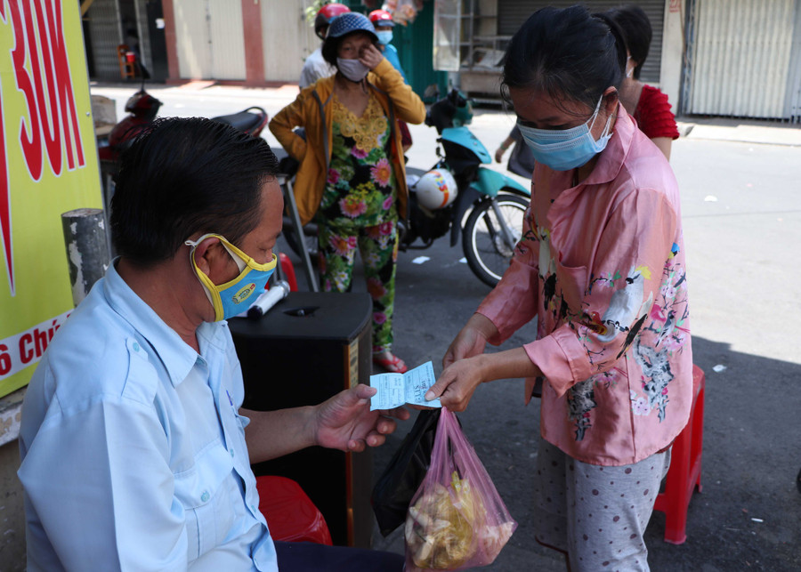 Việc phát phiếu cho người dân đi chợ được nhiều phường, xã áp dụng từ cuối tháng 6.2021. Ảnh: Thanh Hương