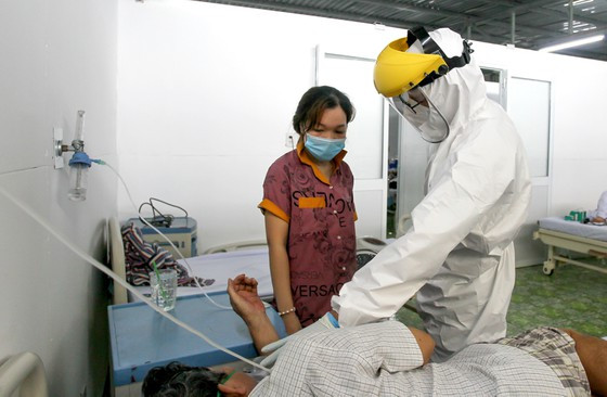 Bác sĩ Ngô Quốc Việt (Bệnh viện đa khoa Xuyên Á) tư vấn, hướng dẫn bệnh nhân cùng người nhà cách hô hấp bằng oxy. Ảnh: Hoàng Hùng