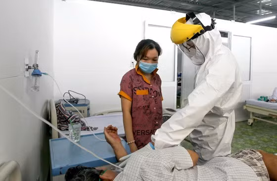 Bác sĩ Ngô Quốc Việt (Bệnh viện đa khoa Xuyên Á) tư vấn, hướng dẫn bệnh nhân cùng người nhà cách hô hấp bằng oxy. Ảnh: Hoàng Hùng