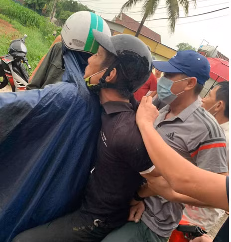 Lê Đăng Tuấn (ngồi giữa) bị công an áp giải về trụ sở sau khi bị bắt giữ