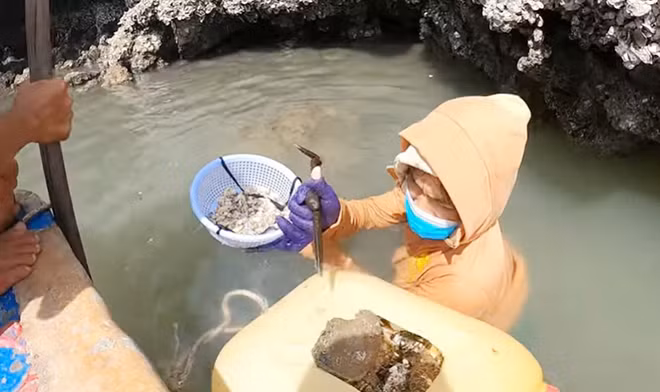 Tay cầm rổ hàu, lưng kéo theo can nhựa làm phao cứu sinh.