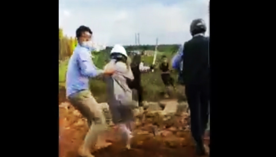 Hai thanh niên quay lại dùng rựa chém về phía nhóm bảo vệ. Ảnh cắt từ clip.