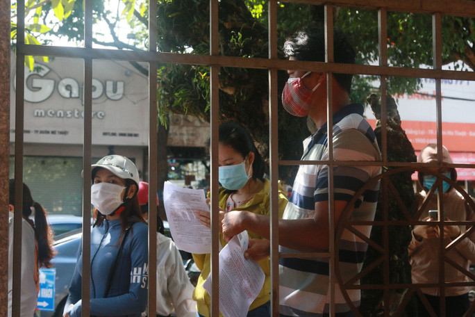 Người thất nghiệp đứng chờ ngoài cổng