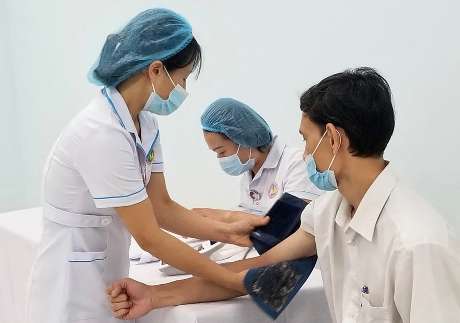 Bác sĩ khám sàng lọc sức khỏe cho người tiêm tại Bệnh viện Đa khoa tỉnh. Ảnh: Như Nguyện