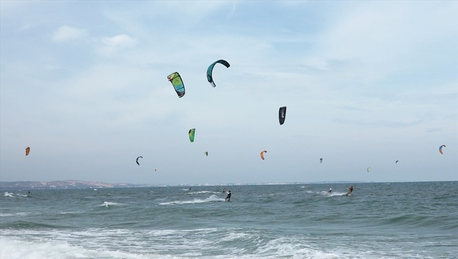 Du khách lướt ván diều trên biển. Ảnh: Phạm Duy