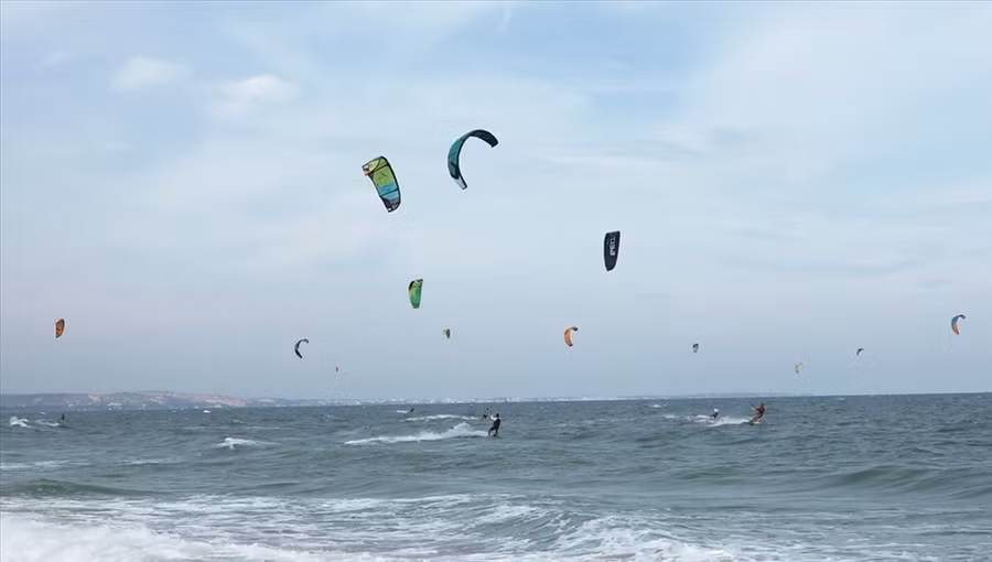 Du khách lướt ván diều trên biển. Ảnh: Phạm Duy