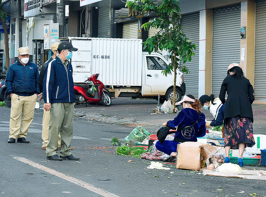 Lực lượng chức năng phường Tây Sơn (TP. Pleiku) nhắc nhở các tiểu thương thực hiện nghiêm Chỉ thị 16 của Thủ tướng Chính phủ. Ảnh: Đức Thụy
