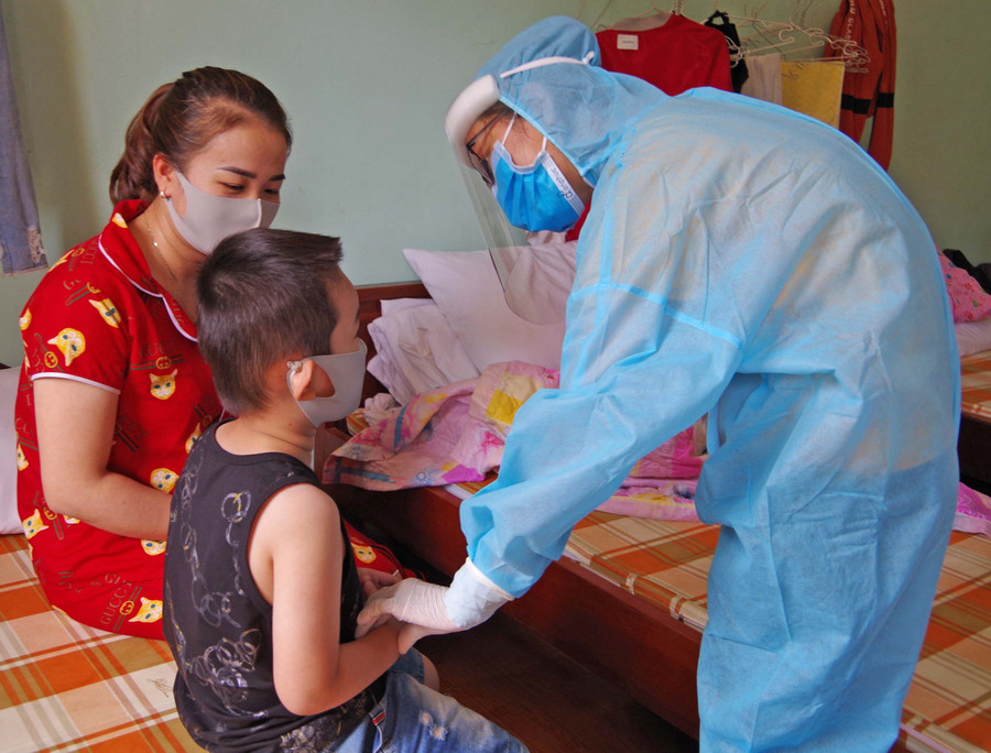 Thượng úy, bác sĩ Lê Thị Hoài Tâm thăm khám sức khỏe cho công dân tại khu cách ly Trung tâm Huấn luyện, bồi dưỡng kiến thức quốc phòng-an ninh (Bộ Chỉ huy Quân sự tỉnh). Ảnh: Phan Lài