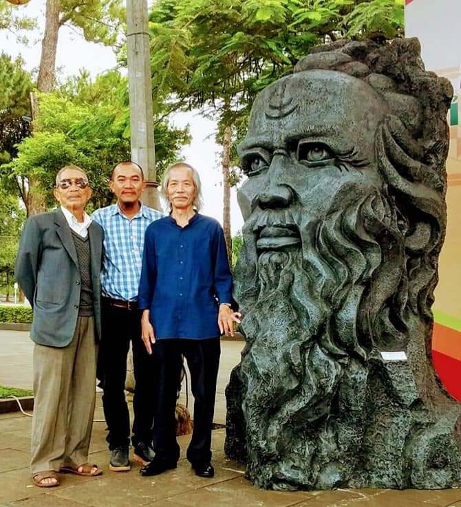 Đoàn (bìa phải)-Chủ tịch Hội Mỹ thuật Việt Nam chụp ảnh lưu niệm bên tác phẩm tượng Anh hùng Núp (ảnh chụp trước tháng 4-2021). Ảnh: Phương Duyên