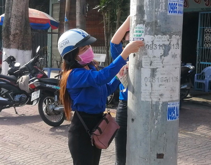  Đoàn viên, thanh niên phường An Bình (thị xã An Khê) bóc gỡ tờ rơi quảng cáo trên cột điện. Ảnh: Ngọc Minh