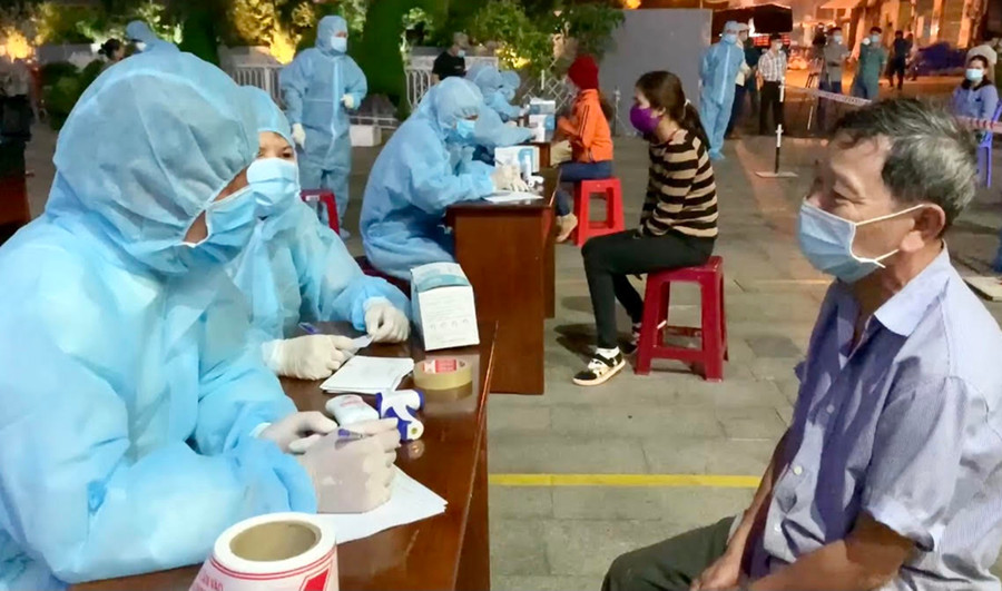 Nhân viên y tế điều tra thông tin y tế trước khi thực hiện lấy mẫu xét nghiệm tầm soát SARS-CoV-2 cho người dân. Ảnh: Như Nguyện