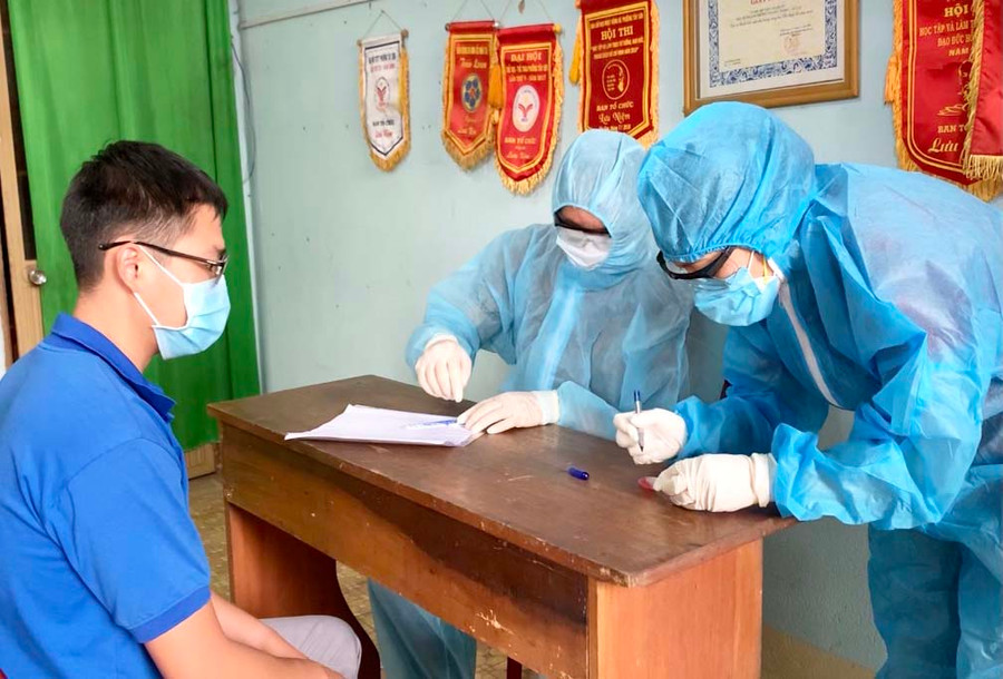 Cán bộ y tế lưu lại thông tin trước khi lấy mẫu xét nghiệm cho người dân. Ảnh: Như Nguyện