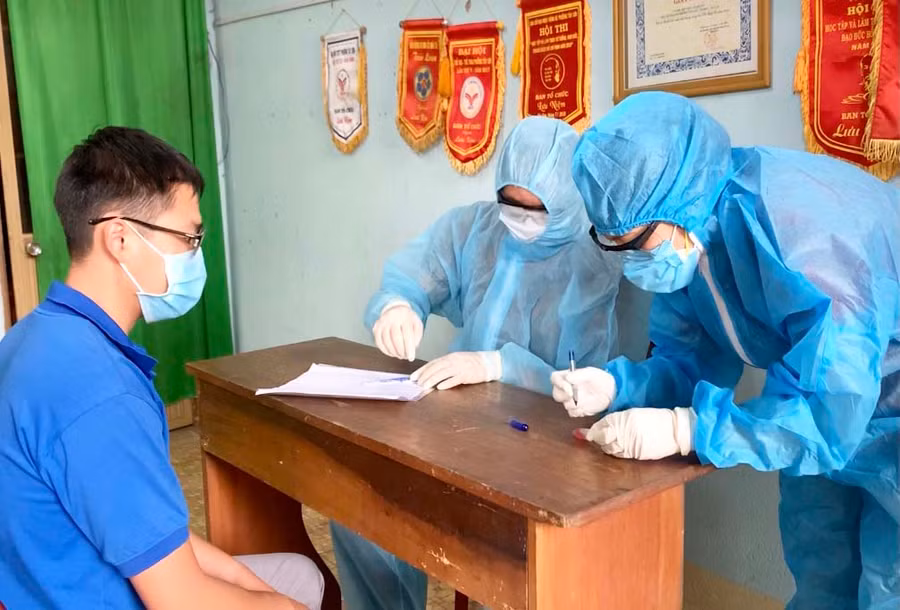 Cán bộ y tế lưu lại thông tin trước khi lấy mẫu xét nghiệm cho người dân. Ảnh: Như Nguyện