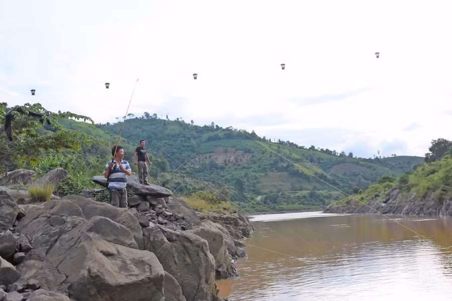 Các “cần thủ” câu cá dưới chân đập thủy điện Sê San 3. Ảnh: Minh Nguyễn