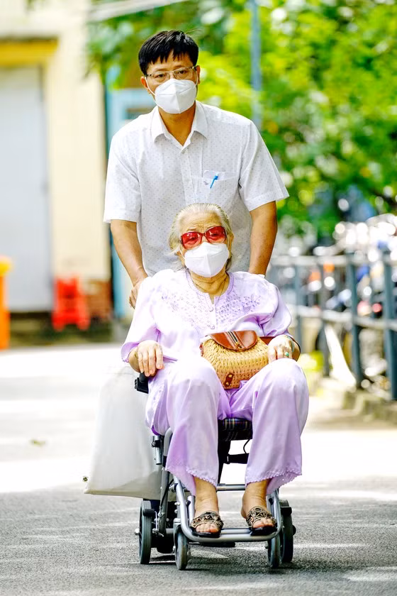 Đưa mẹ đi tiêm vaccine Covid-19 tại BV Nguyễn Văn Thịnh, TP Thủ Đức. Ảnh: HOÀNG HÙNG