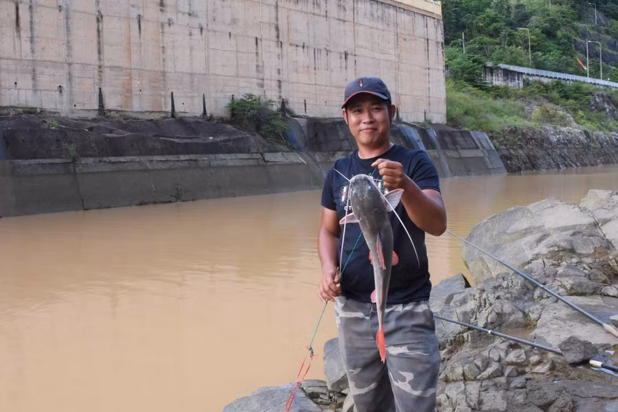 Cần thủ Vũ Đình Quỳnh với con cá lăng nặng gần 2 kg vừa câu được.