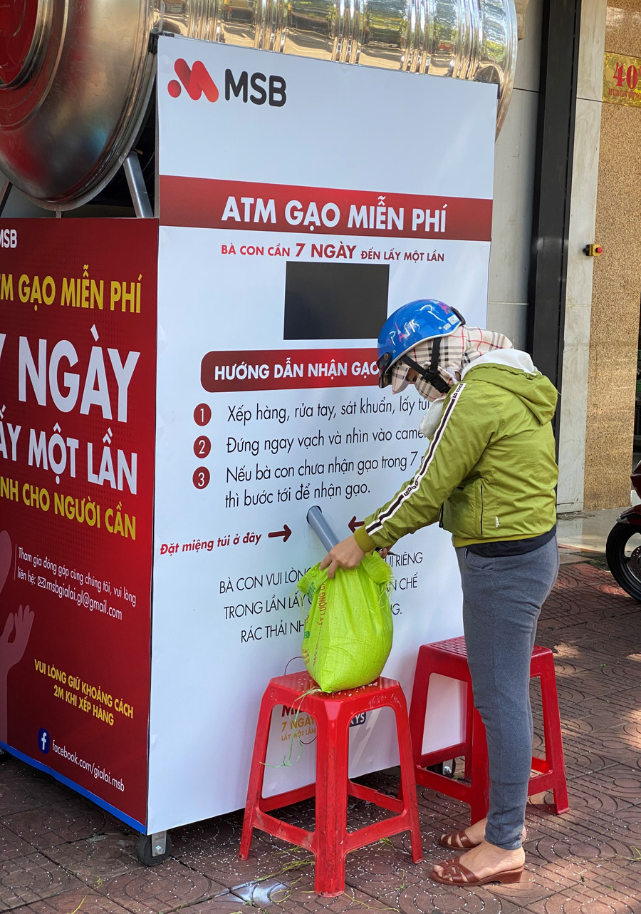 Người dân đến nhận gạo tại “cây ATM gạo”. Ảnh: Hà Đức Thành