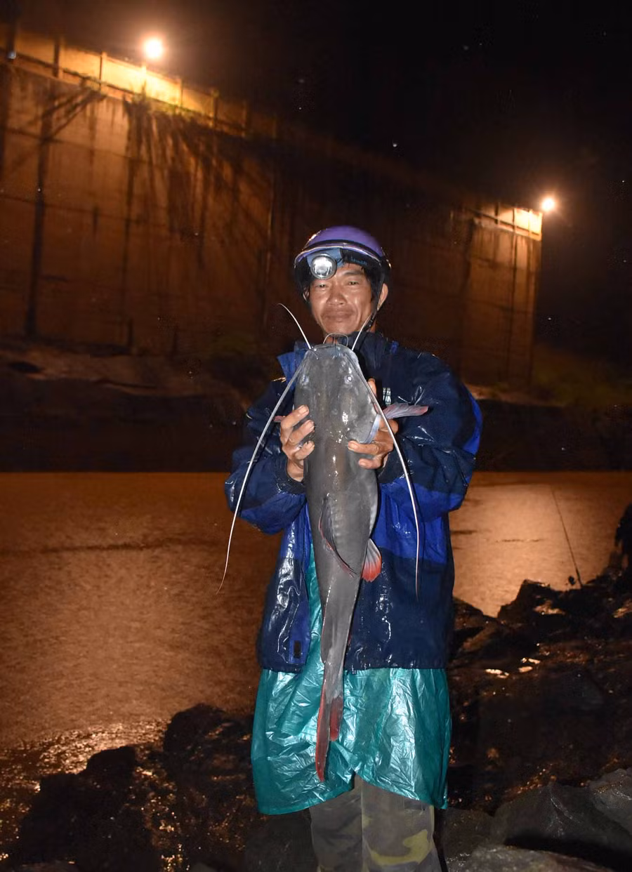 Anh Trần Đình Toản chinh phục được một con cá lăng nặng gần 7 kg sau một đêm thức trắng.