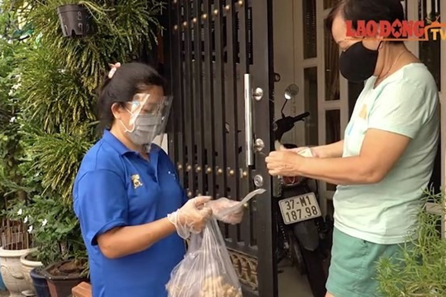 Người dân TPHCM được cán bộ tổ công tác hỗ trợ đi chợ giúp. Ảnh: Ngọc Lê