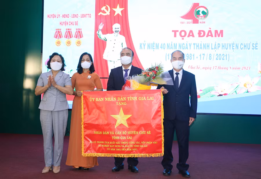 Thừa ủy nhiệm của Chủ tịch UBND tỉnh, Phó Chủ tịch HĐND tỉnh Ayun H’Bút tặng cờ “Vì sự nghiệp xây dựng và bảo vệ tỉnh Gia Lai” cho Nhân dân và cán bộ huyện Chư Sê. Ảnh: Quang Tấn