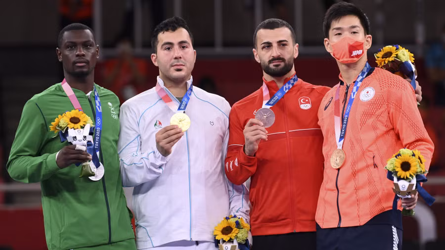 Khuôn mặt vô cảm của 2 VĐV nhận HCV và HCB (từ trái sang) trên bục trao thưởng. Ảnh: Reuters