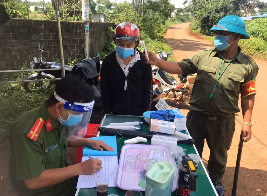  Lực lượng chức năng kiểm tra thân thiệt, lấy thông tin liên hệ của công dân khi đi qua các chốt kiểm soát dịch Covid-19 do thành phố bố trí. Ảnh: Lê Hòa
