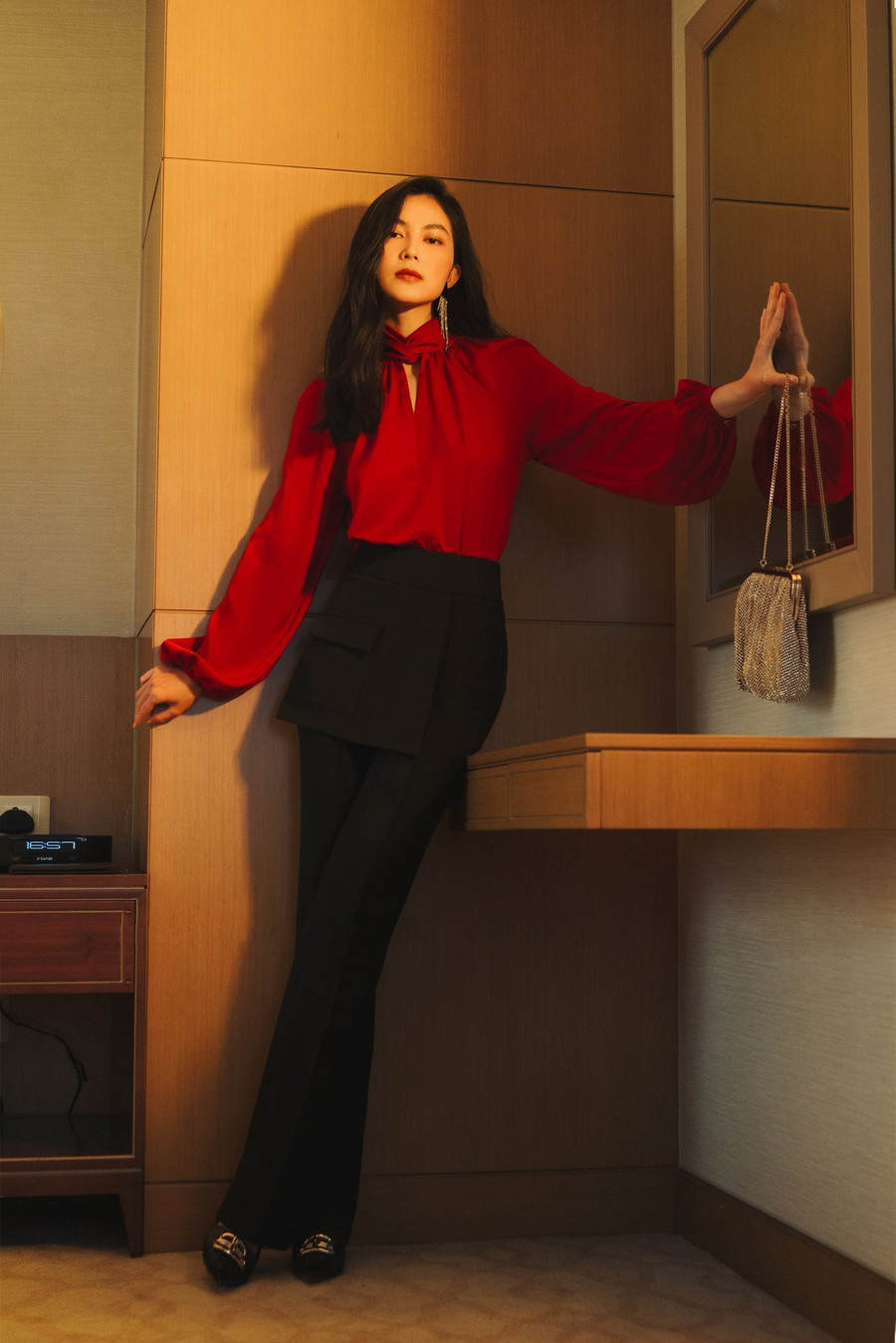 Áo blouse khai thác trên chất liệu lụa thanh thoát, gây ấn tượng bằng chi tiết draping xếp nếp nơi cổ - thân áo, chi tiết cổ xếp 3D giao nhau đắt giá, cùng thiết kế tay raglan với độ phồng rủ mềm mại.