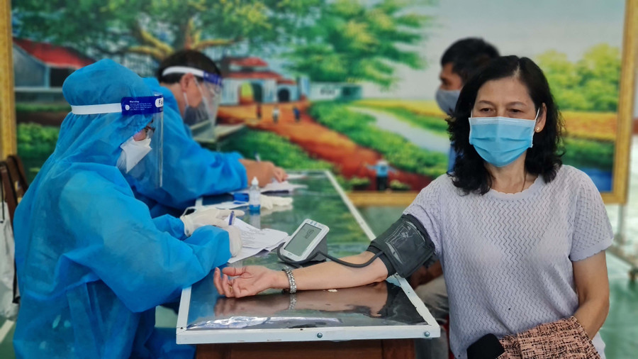 Nhân viên y tế kiểm tra huyết áp người dân trước khi tiêm vắc xin phòng Covid-19 tại điểm tiêm trường Nguyễn Văn Trỗi (phường Hoa Lư, TP. Pleiku). Ảnh: Bá Bính