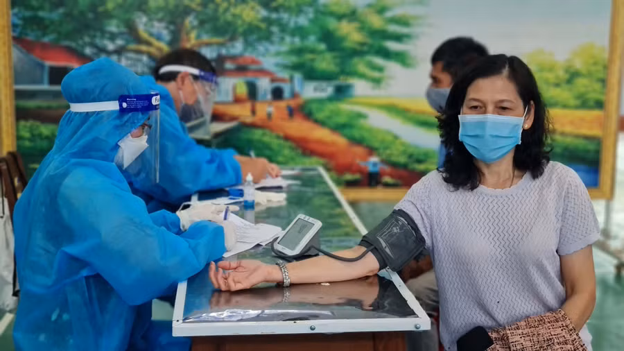 Nhân viên y tế kiểm tra huyết áp người dân trước khi tiêm vắc xin phòng Covid-19 tại điểm tiêm trường Nguyễn Văn Trỗi (phường Hoa Lư, TP. Pleiku). Ảnh: Bá Bính