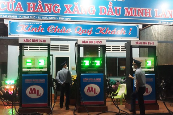 Đoàn kiểm tra của Cục Quản lý thị trường tỉnh Bình Định kiểm tra đột xuất ban đêm tại 1 cửa hàng xăng dầu trên địa bàn. Ảnh: PHƯƠNG THẢO