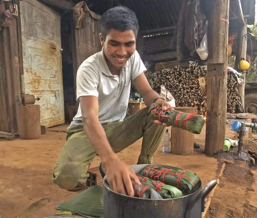 Anh Rơ Mah Briu xếp từng chiếc bánh tét vào nồi. Ảnh: Anh Huy