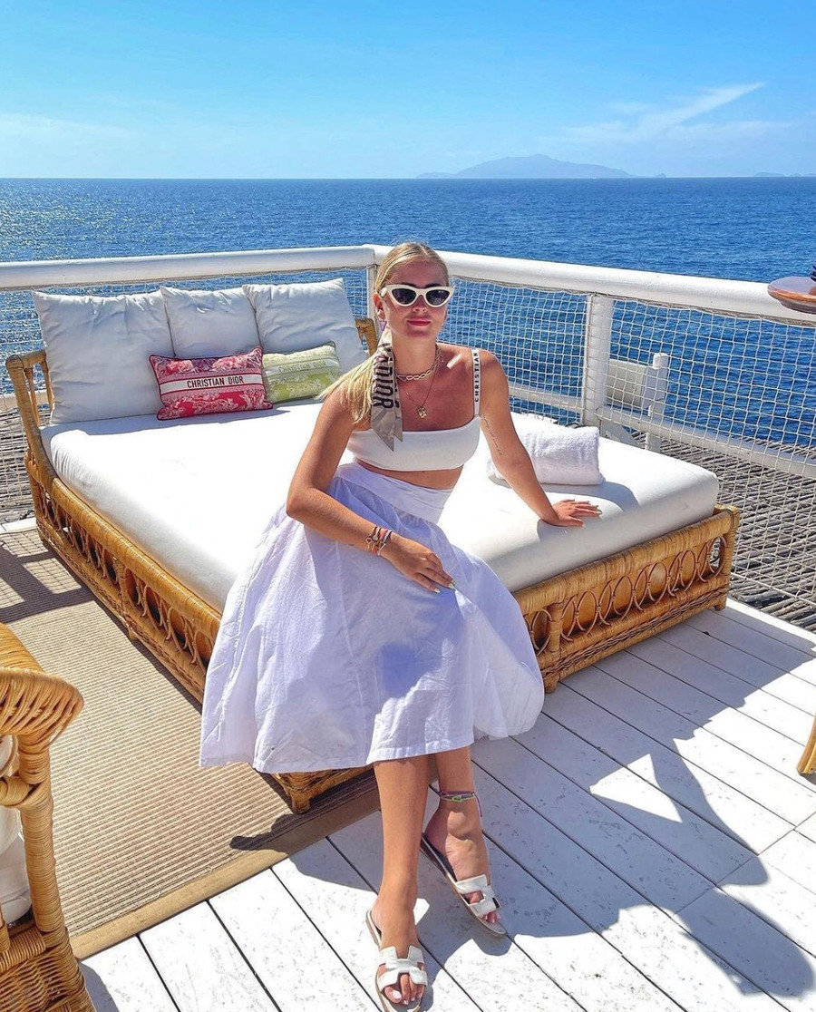 Để có vẻ ngoài hiện đại pha chút hoài cổ, hãy kết hợp một chiếc midi loe thập niên 50 với một chiếc bra kiểu thể thao, tăng thêm vẻ quyến rũ cổ điển bằng khăn lụa Dior buộc tóc và kính râm mắt mèo màu trắng.