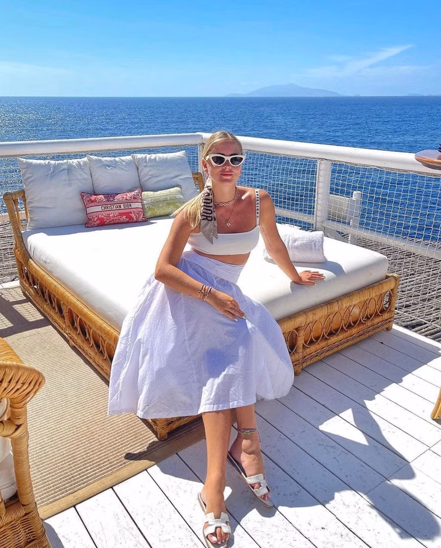 Để có vẻ ngoài hiện đại pha chút hoài cổ, hãy kết hợp một chiếc midi loe thập niên 50 với một chiếc bra kiểu thể thao, tăng thêm vẻ quyến rũ cổ điển bằng khăn lụa Dior buộc tóc và kính râm mắt mèo màu trắng.