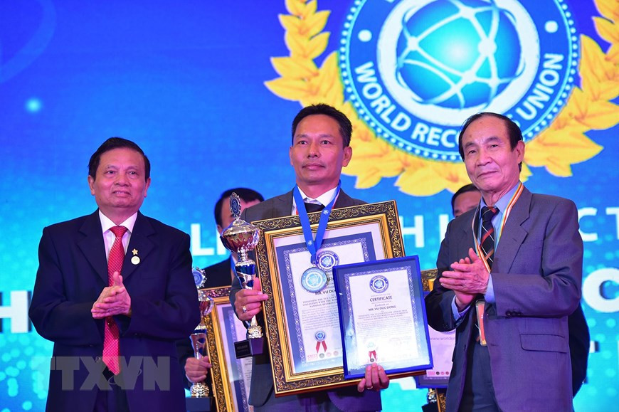 Ông Vũ Đức Đông nhận Bằng công nhận xác lập kỷ lục thế giới ''Bộ sưu tập mai vàng Tuệ Sâm có nhiều tác phẩm độc bản nhất''.Ảnh: Nhựt An/TTXVN
