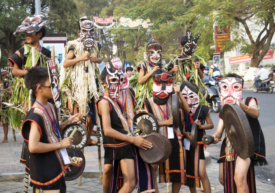 Trẻ em dân tộc Bahnar đeo mặt nạ biểu diễn trong lễ hội đường phố. Ảnh: Tấn Vịnh