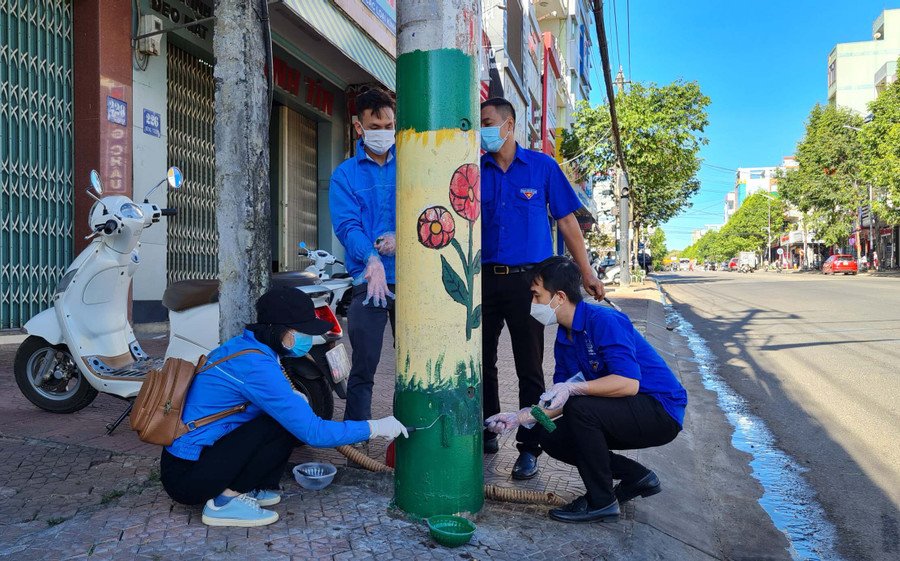 Đoàn viên, thanh niên TP. Pleiku sơn vẽ trụ điện trên tuyến đường Hùng Vương. Ảnh: Phan Lài