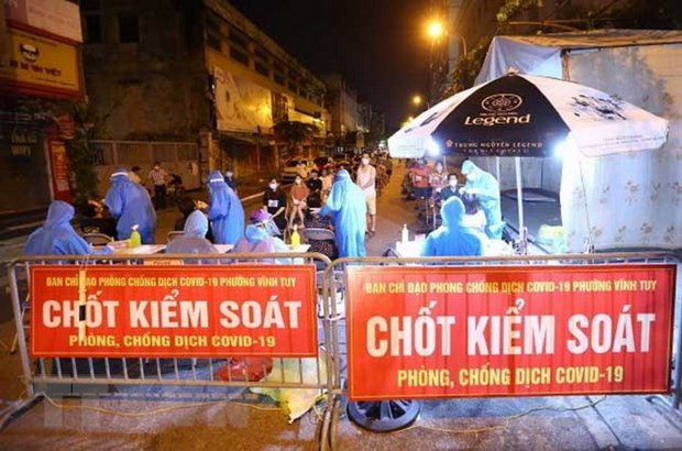 Nhân viên y tế quận Hai Bà Trưng (Hà Nội) tổ chức 4 dây chuyền lấy mẫu xét nghiệm COVID-19 cho người dân phố Mạc Thị Bưởi, phường Vĩnh Tuy ngay trong đêm. Ảnh: Hoàng Hiếu/TTXVN